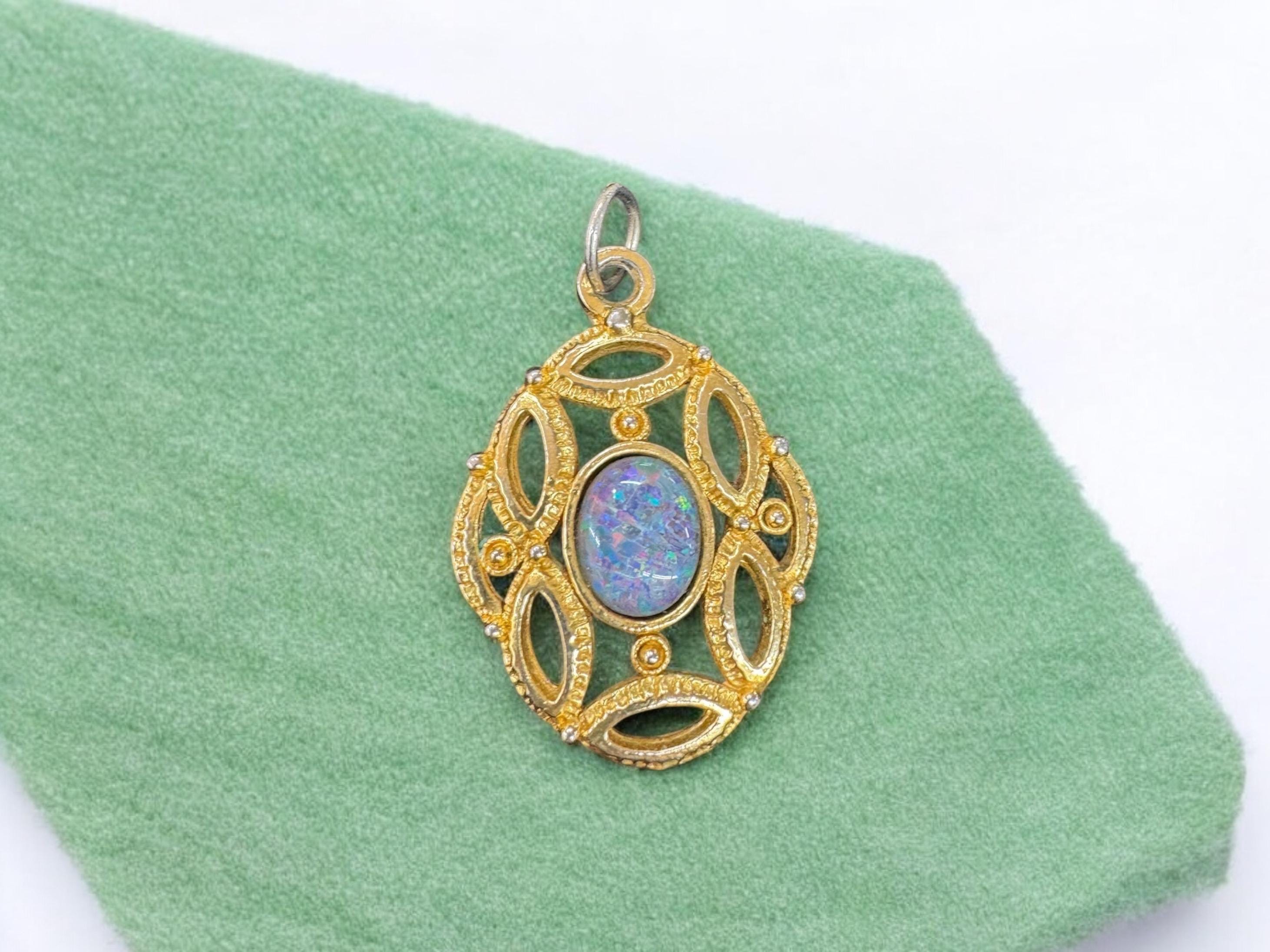 gold color metal pendant with faux opal in middle